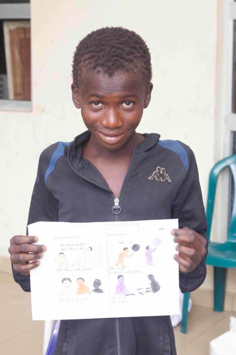 Young person proudly displaying completed artwork